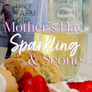 Close up of a scone, fresh strawberries and cream in front of a glass of Fancy Farm Girl Frosty Fizz sparkling vidal.